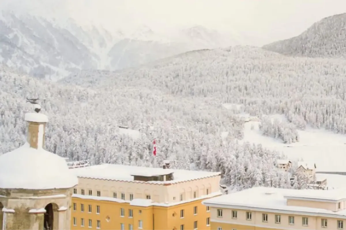 The hotel building with snow-covered peaks in the background at sunrise
