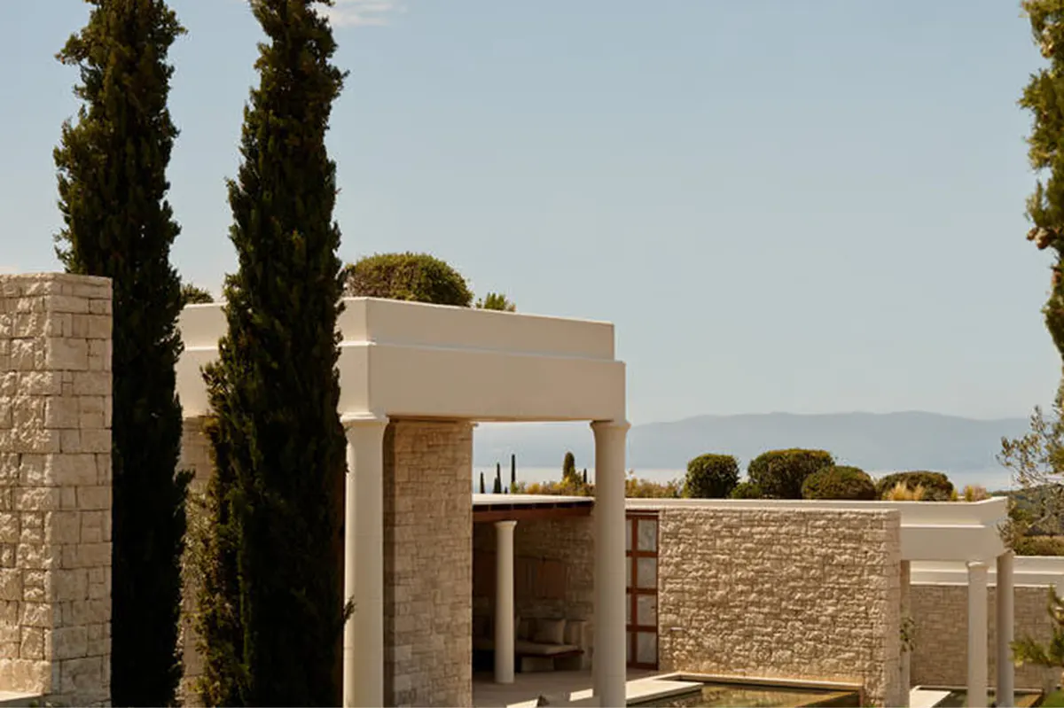 Outdoor terrace at dusk with columned structure and calm water below