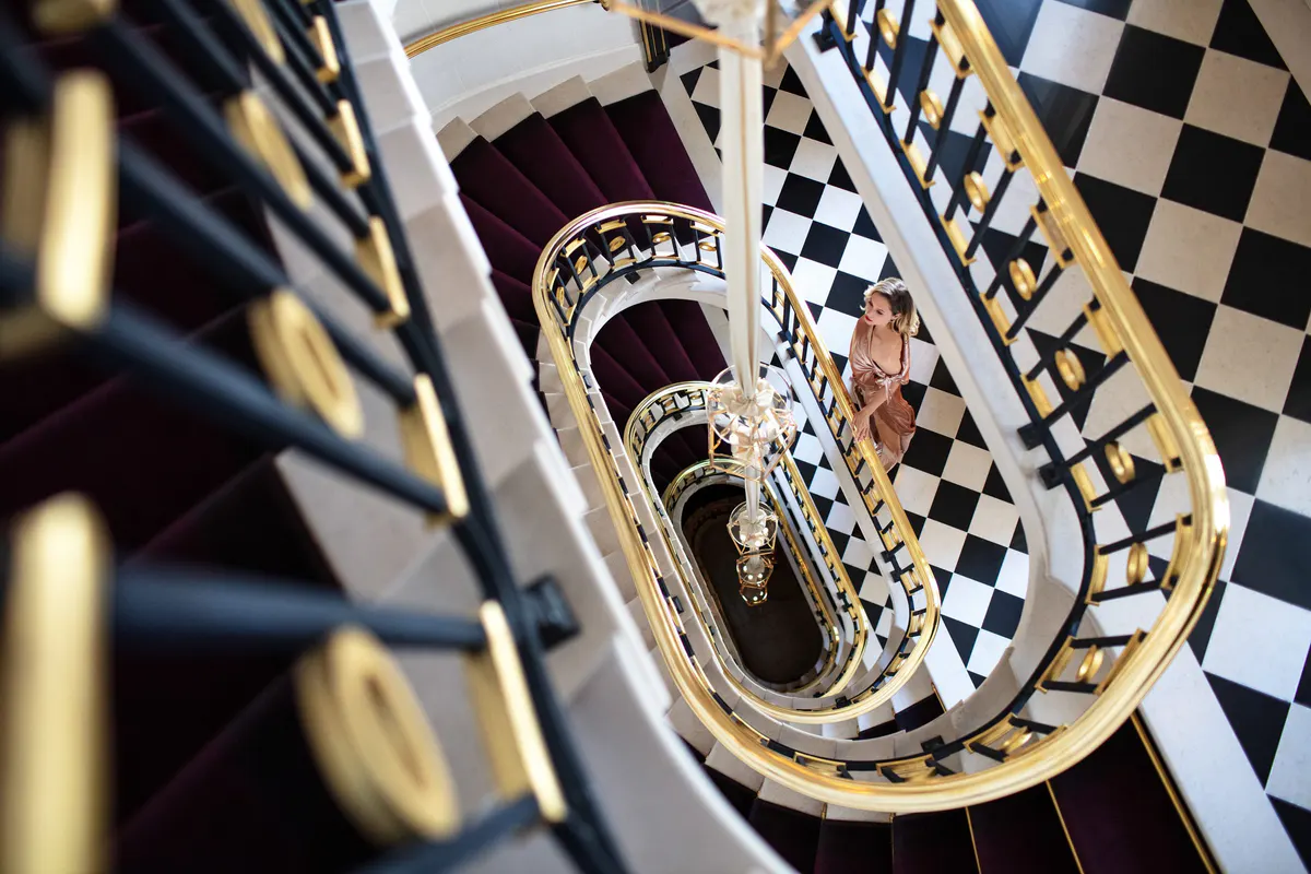 An overhead view of a spiraling staircase with black and white checkerboard pattern