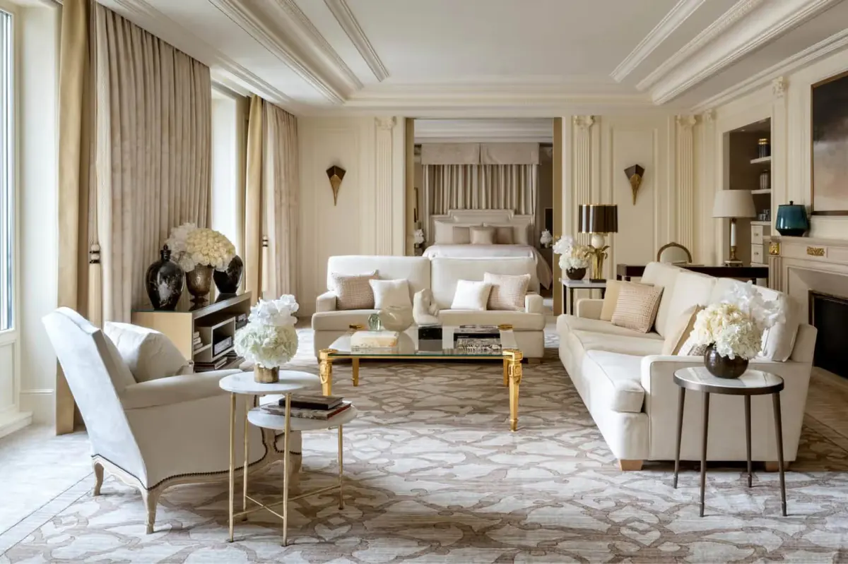 A cream and beige suite with layered window treatments and a marble fireplace
