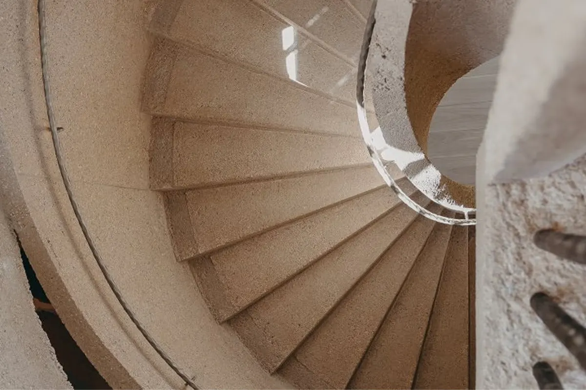 Spiral staircase with natural stone and curved metal railing