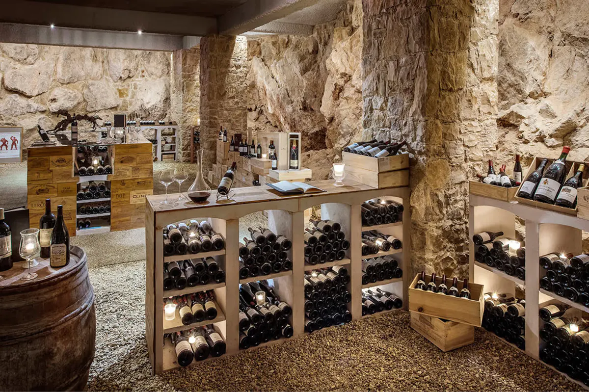 Wine cellar with stone walls displaying bottles in wooden racks