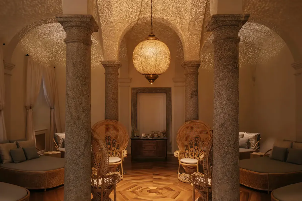 A spa corridor with stone columns, accent lighting, and arched ceiling