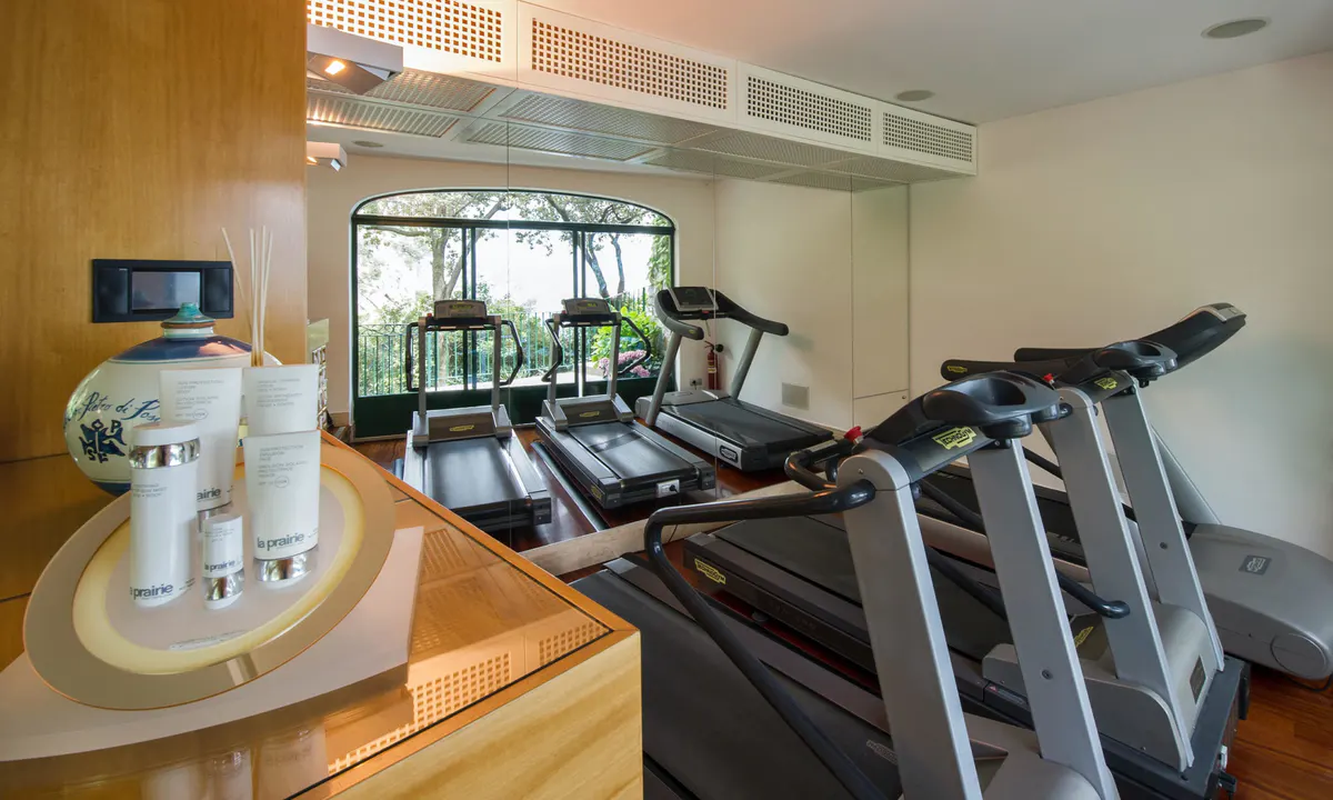 Gym with cardio machines, modern equipment, and minimalist light wood interior