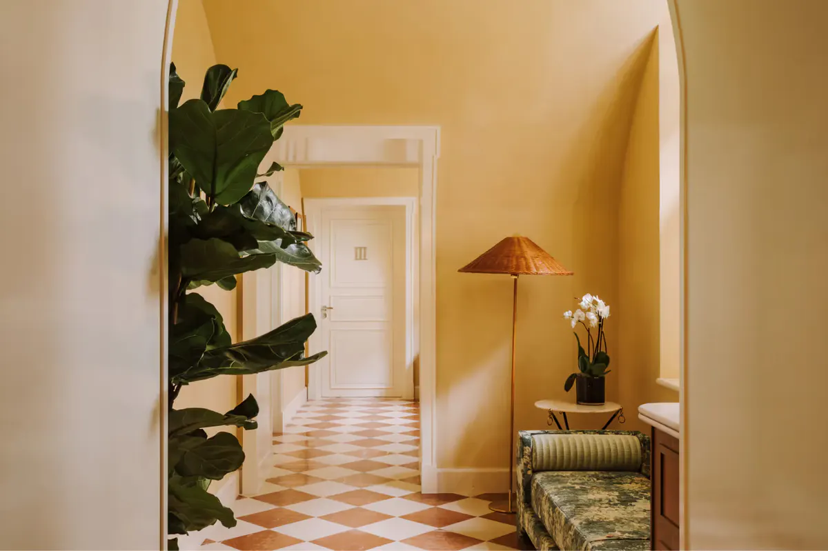 Spa treatment room with yellow ochre walls, dual vanities, and palm plant