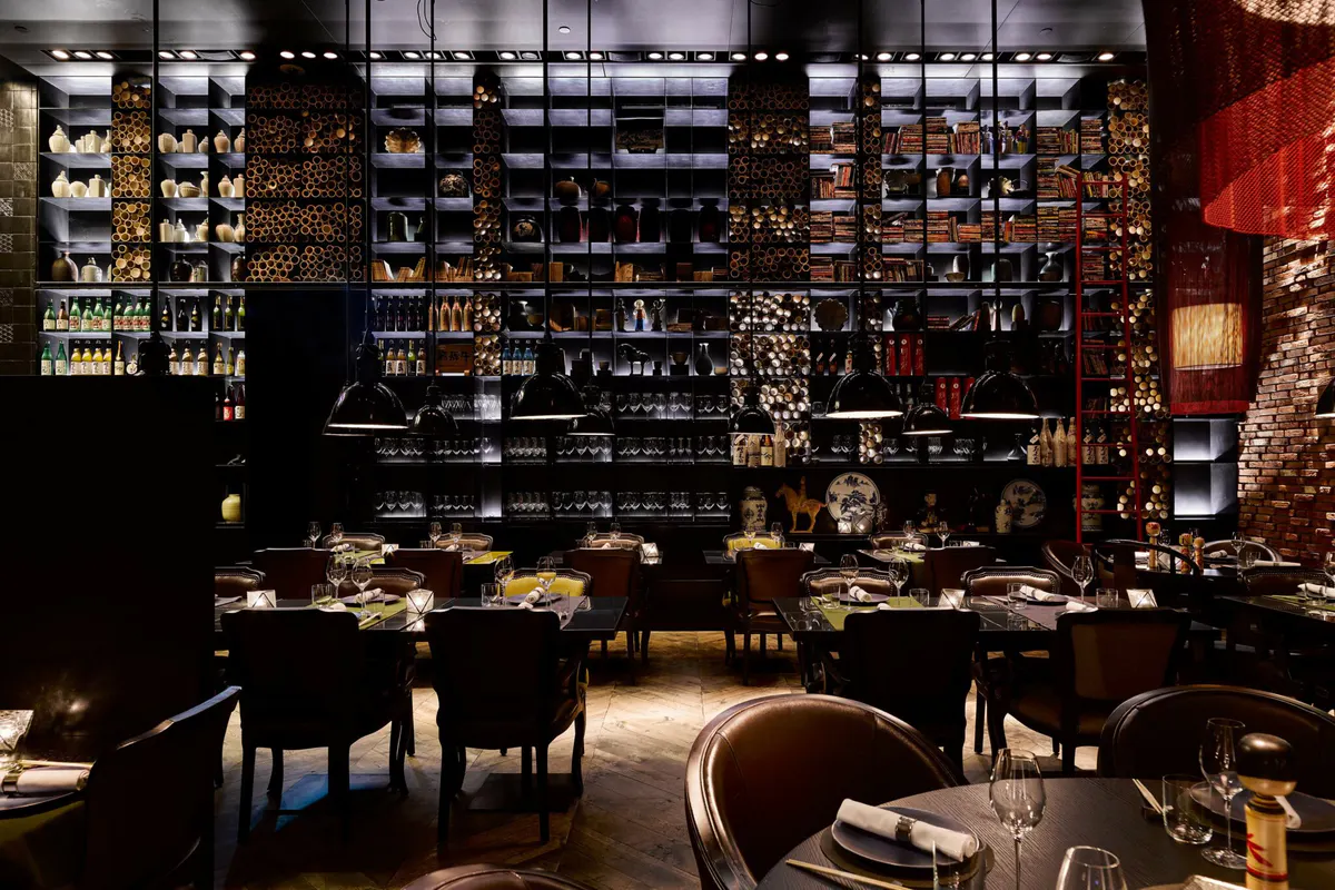 Taiko Bar with dark wood cabinetry displaying spirits, leather seating, and mood lighting