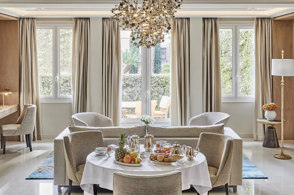 Elegant salon with multiple armchairs arranged around a central table, brass and marble accents