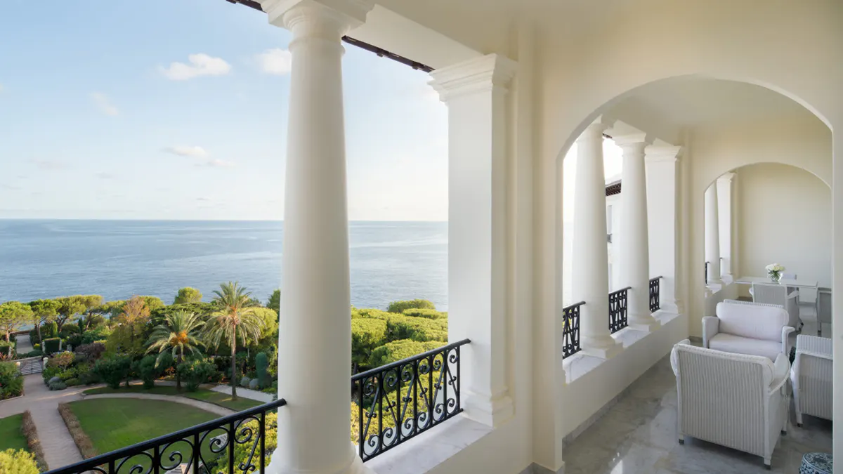 Light-filled colonnade terrace overlooking gardens and the Mediterranean