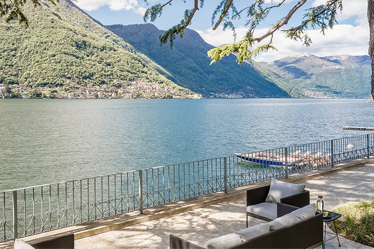 Terrace with lounge seating overlooking lake and mountains at midday