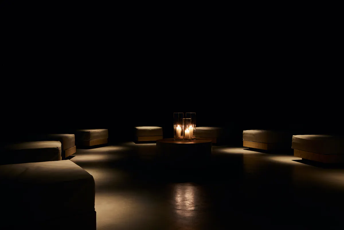 A sauna or wellness room with light wood walls, bench seating, and minimalist architectural details