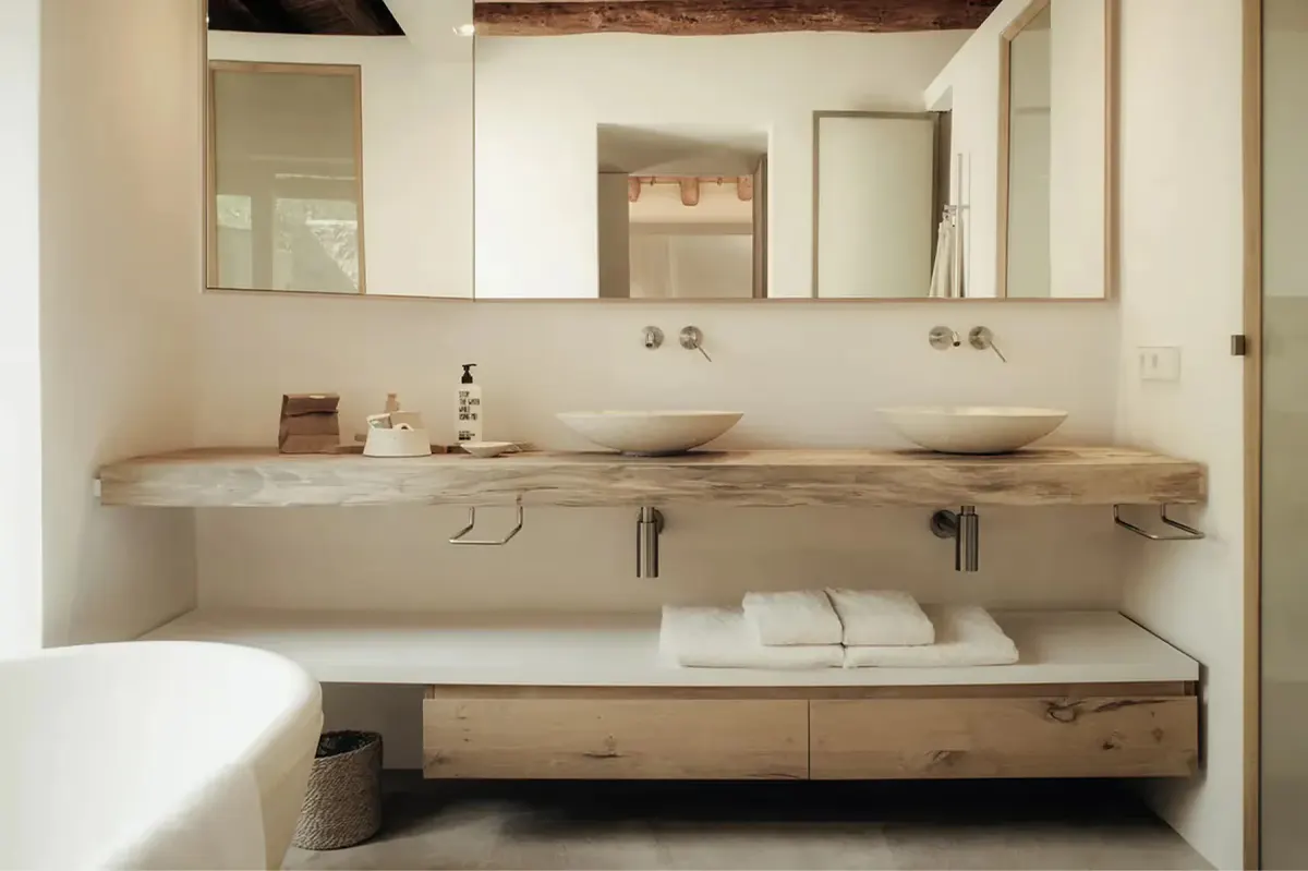 Minimalist bathroom with live-edge wood countertop, paired mirrors, and recessed lighting above sink