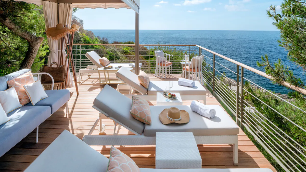 Oceanfront suite terrace with lounge beds and sea-view railing