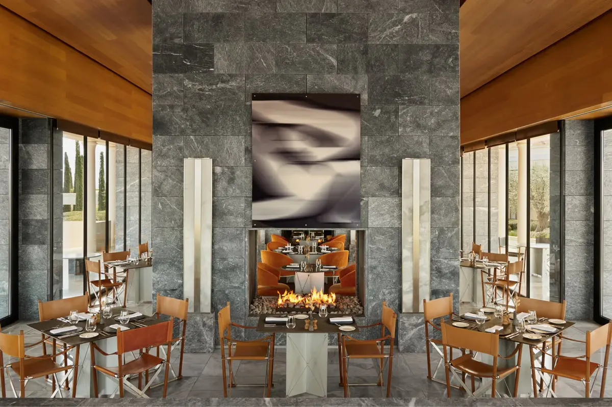Contemporary dining space with marble walls and warm wood accents