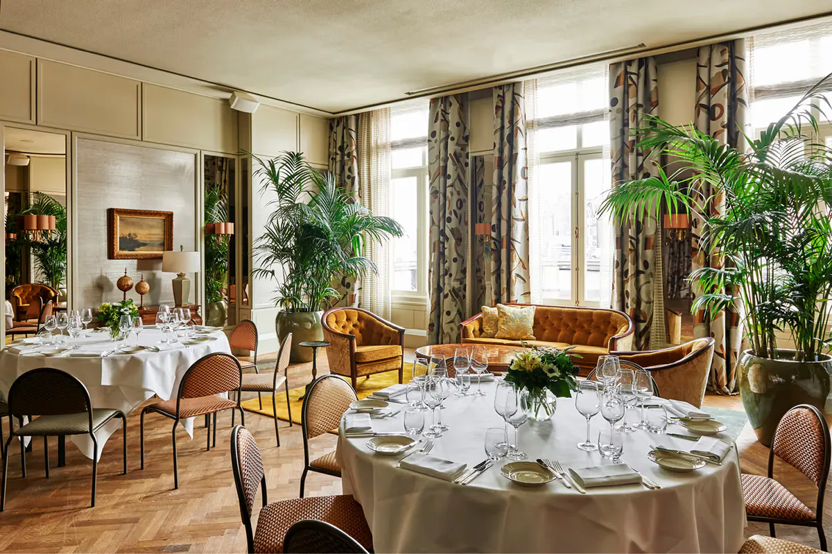 Private dining room with round table, crystal chandelier, and classical architecture