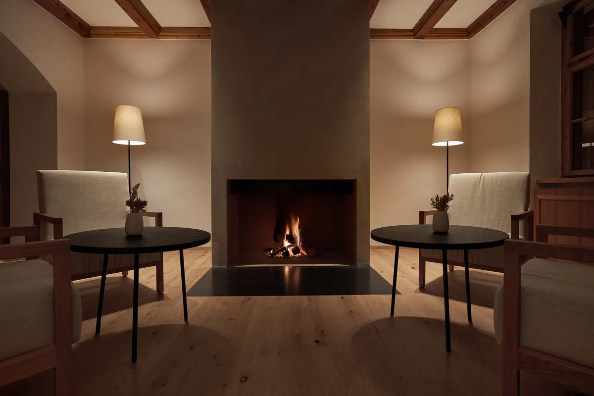 A spa or wellness room with light wood surfaces, a cushioned bench, and a single framed mountain view