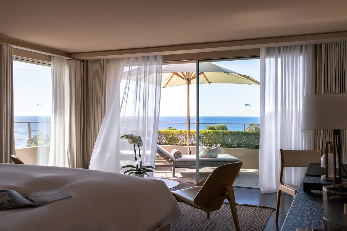 Bedroom with coastal furniture and expansive Mediterranean vista