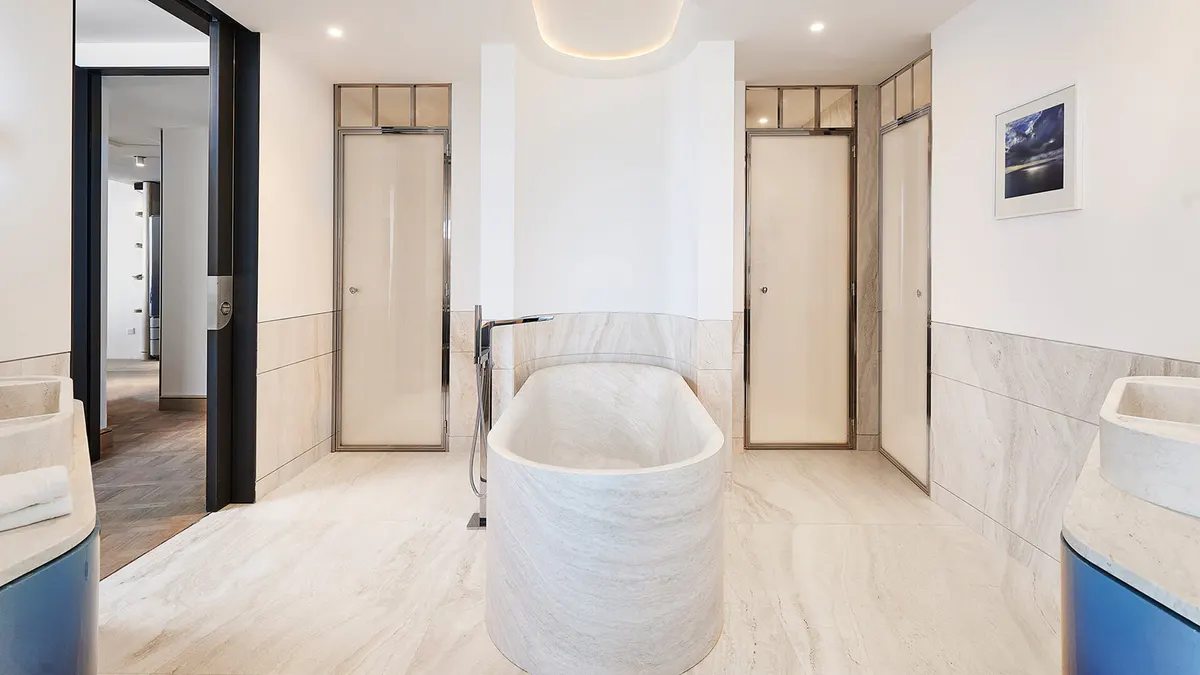Spa-like bathroom with freestanding white tub and sea view