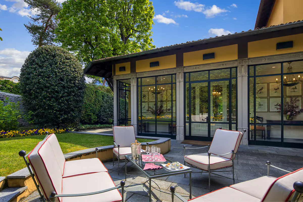 Outdoor terrace with lounge seating and lake views beneath a pergola structure