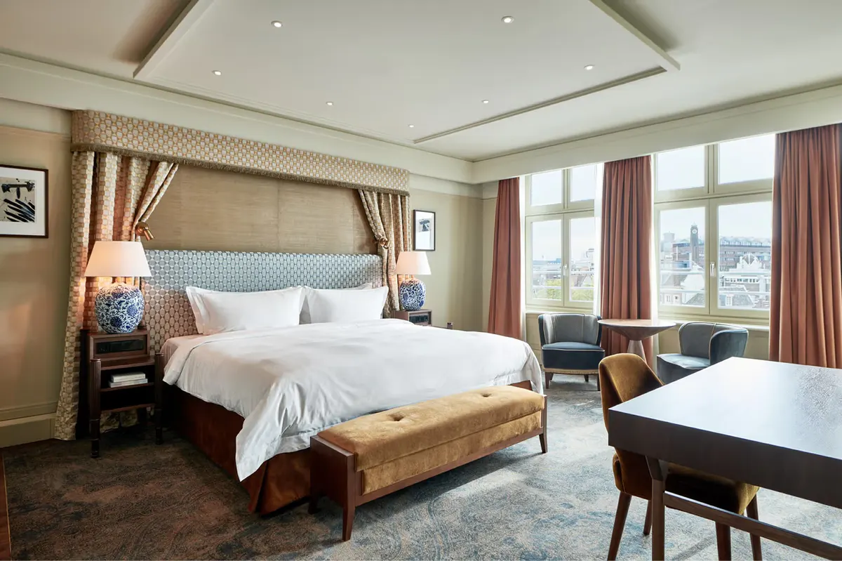 Bedroom with wood-framed bed, decorative wall sconces, and striped furniture