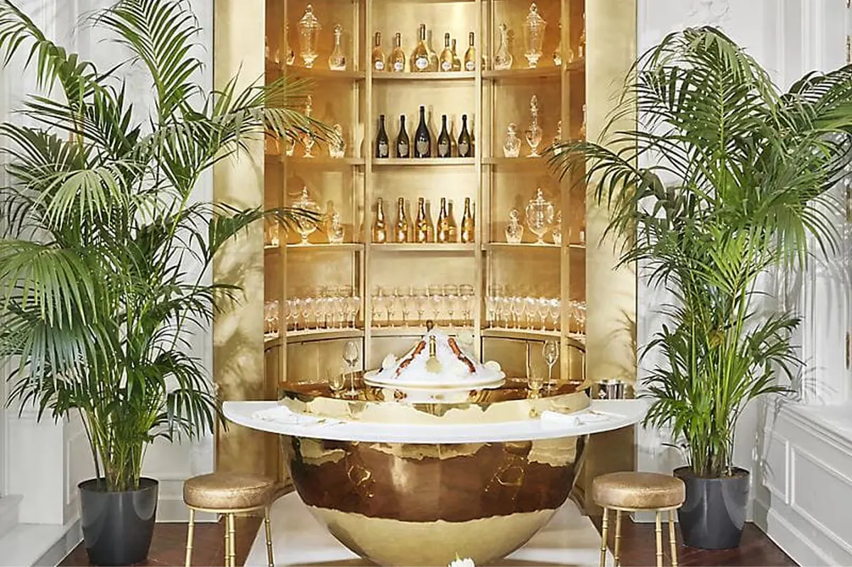 Intimate bar with golden beverage cabinet and palm plant accents
