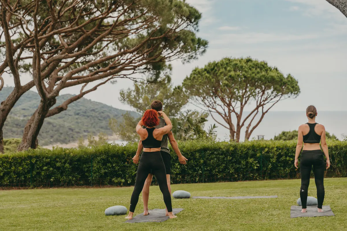 Outdoor fitness class on lawn with instructors and participants