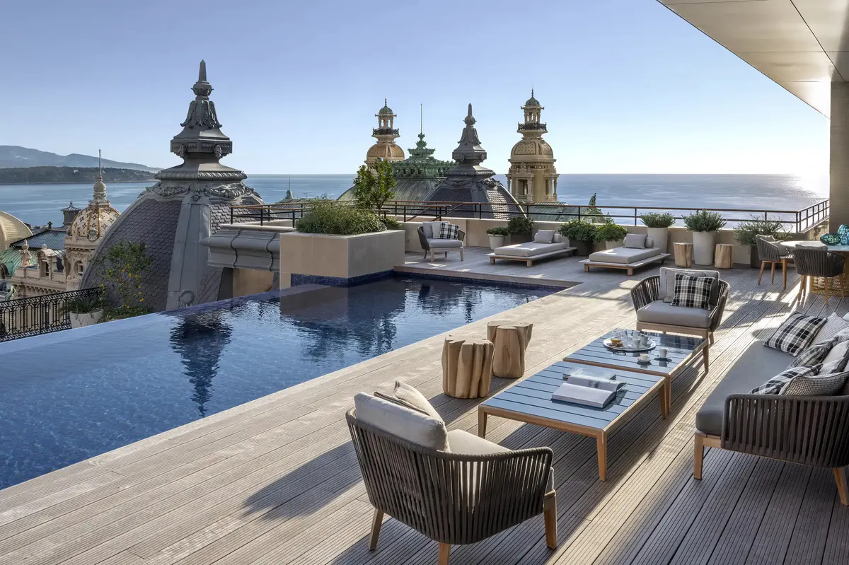 Rooftop terrace with lounge chairs, pool and palazzo views overlooking sea