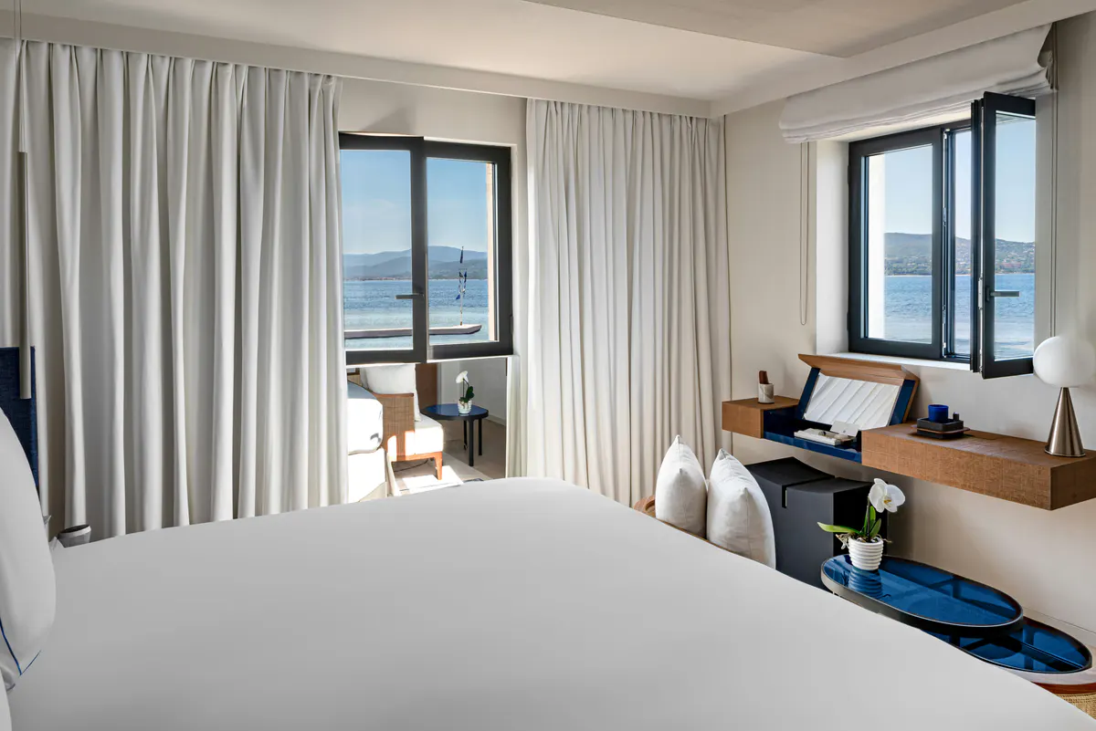 Bedroom with floor-to-ceiling terrace doors and water vista