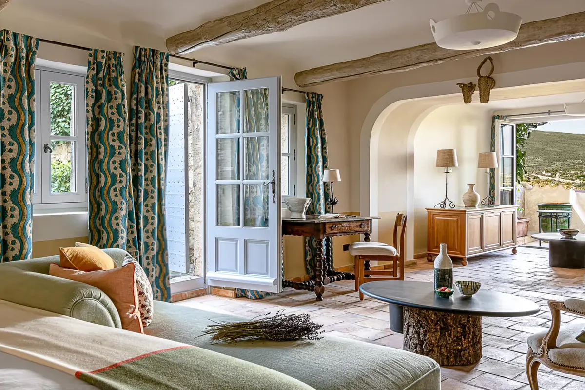 A suite with arched doorways, patterned curtains in muted tones, and views through to outdoor areas