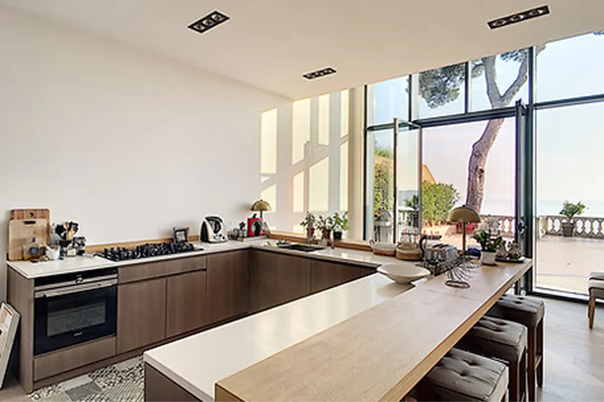 Kitchen with stone counters, dark cabinetry, and expansive windows overlooking coastline