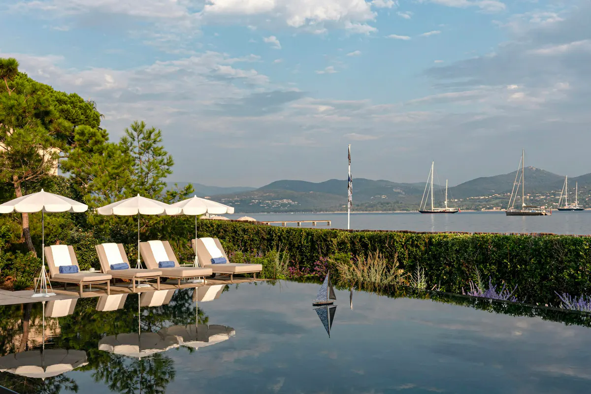 Waterfront pool with sunbeds overlooking moored boats