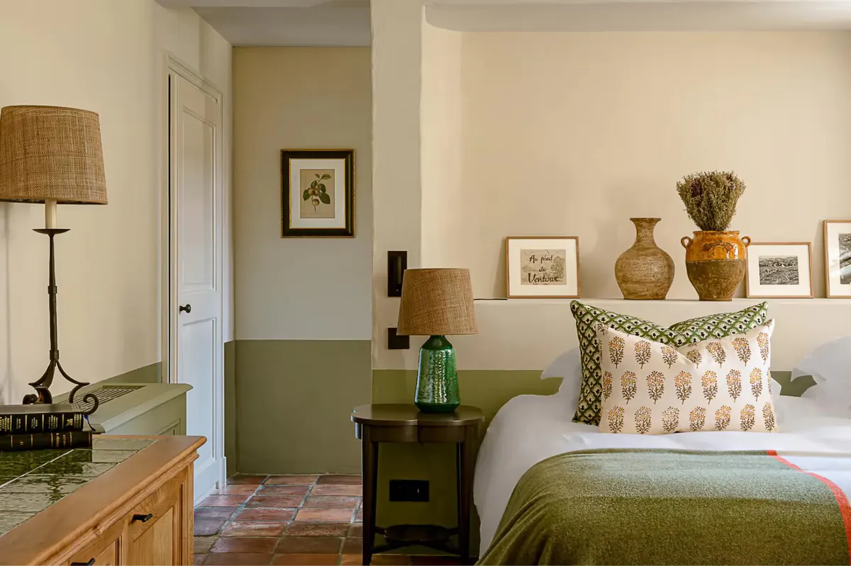 A room with a terracotta-orange sofa, green wall sections, and patterned curtains with upholstered chairs