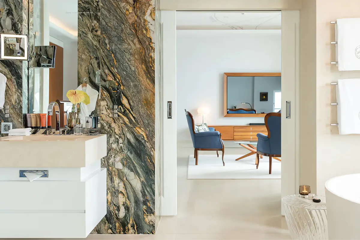 Bathroom with natural stone wall and view into bedroom