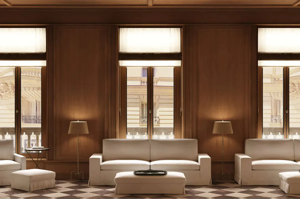 A wood-paneled salon with multiple windows, seating, and a fireplace