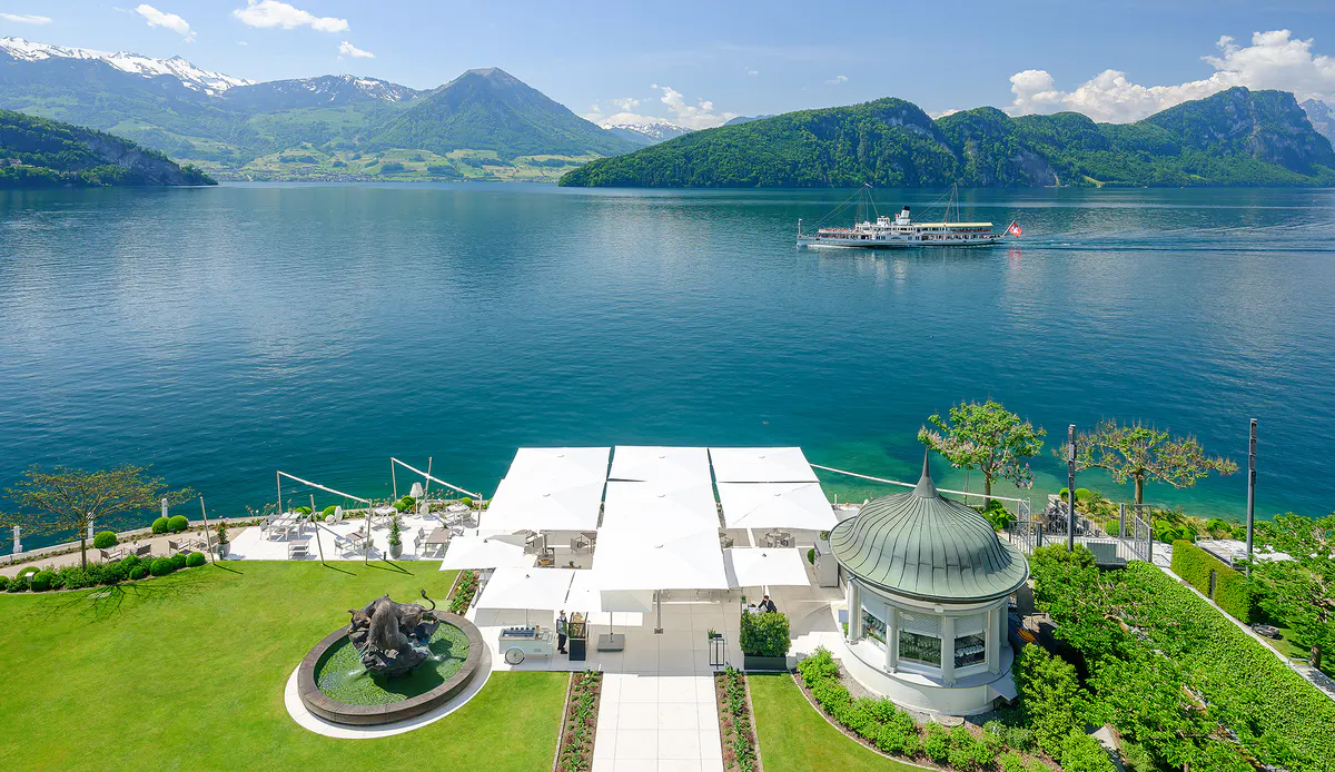 Hotel rooftop view overlooking lake with Alps and rowing boats visible