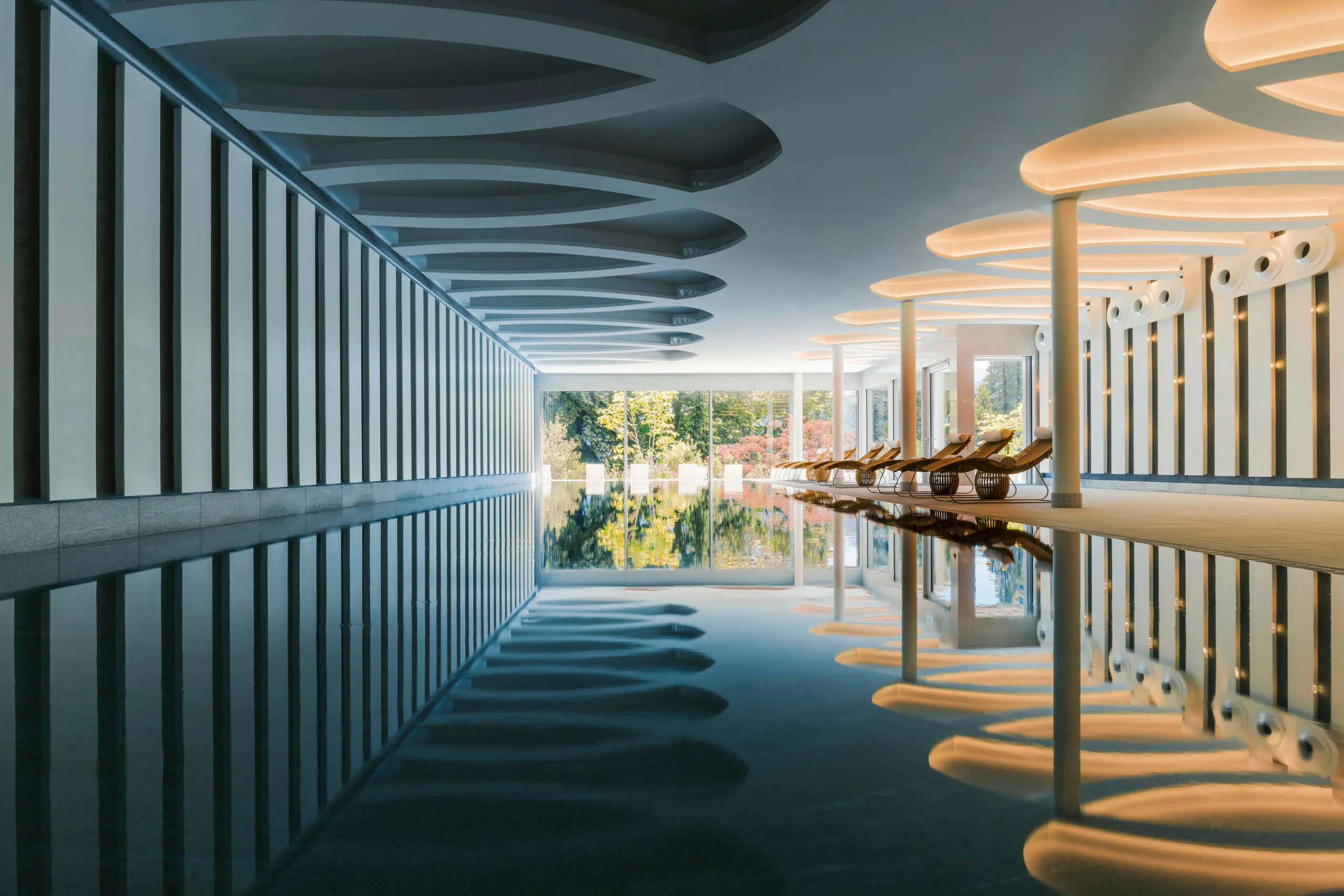 A sculptural indoor pool opening onto gardens near Lucerne