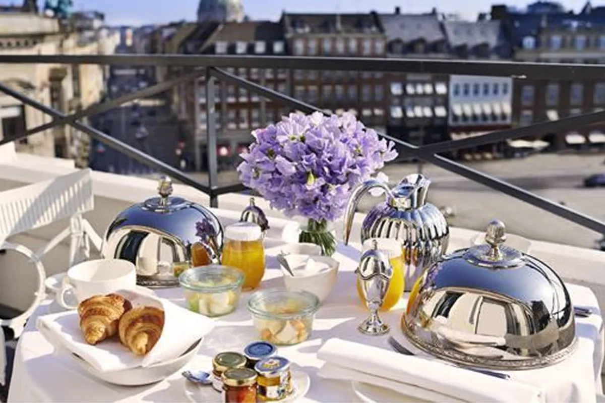 Rooftop table setting with city skyline and purple floral arrangement