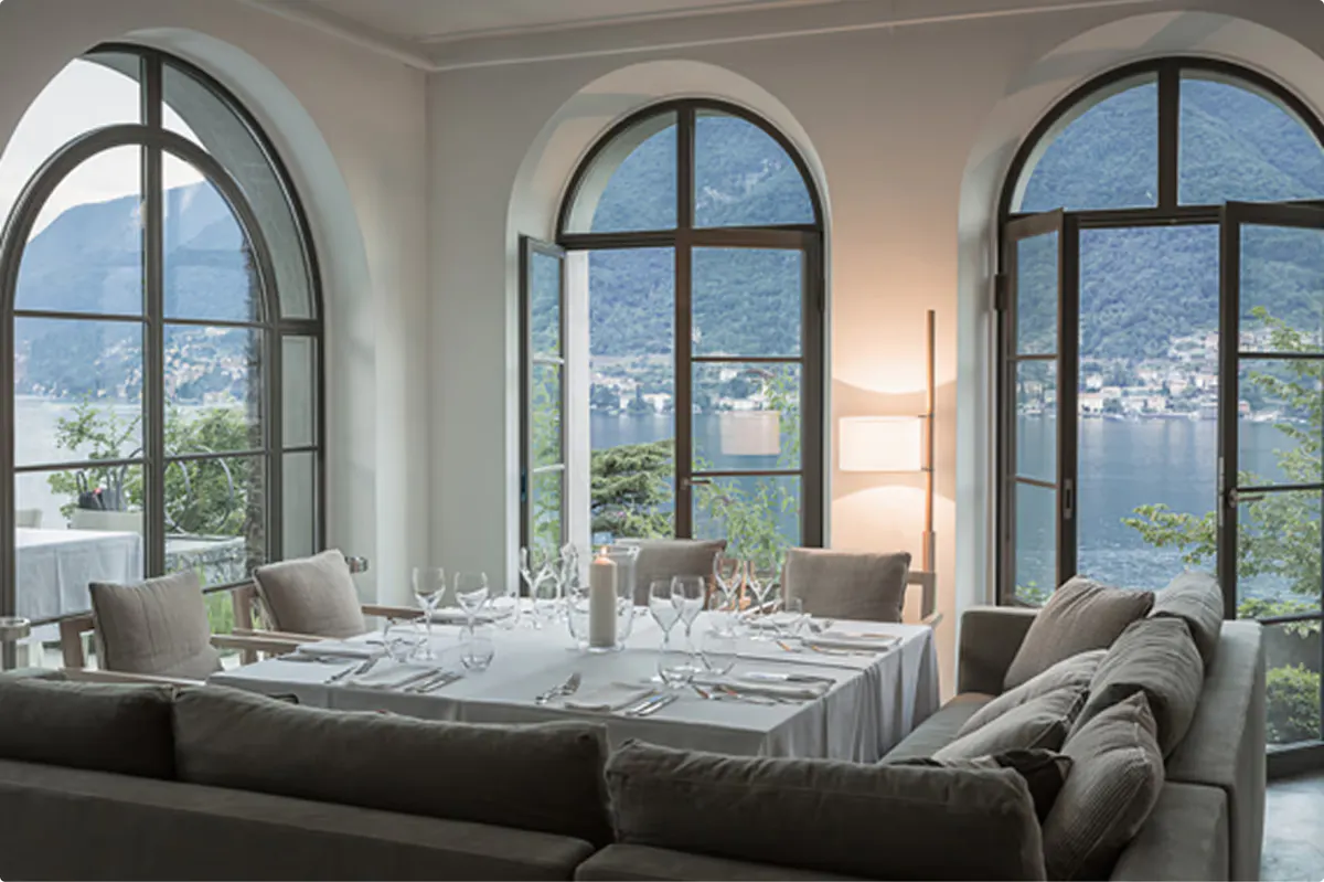 Formal dining room with set table and expansive views of the lake and mountains