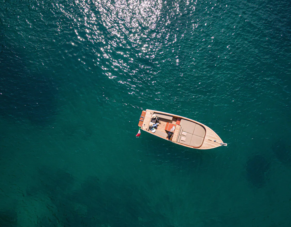 Boat moored in clear turquoise water from above