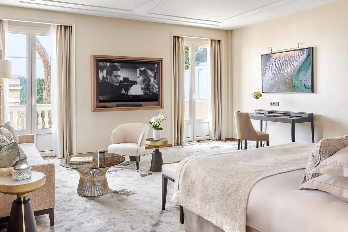 Bedroom with two queen beds, neutral tones, and views to the terrace