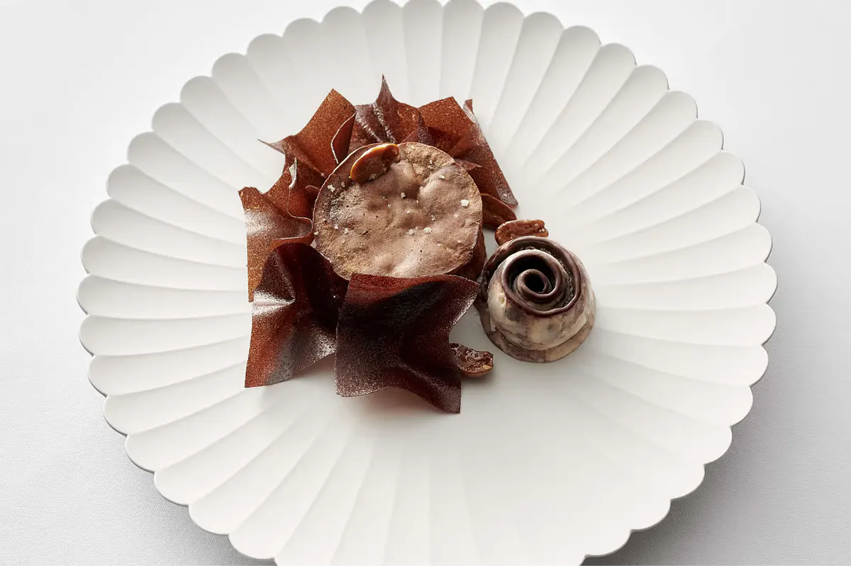 Single plated course on white porcelain with garnish and sauce arrangement