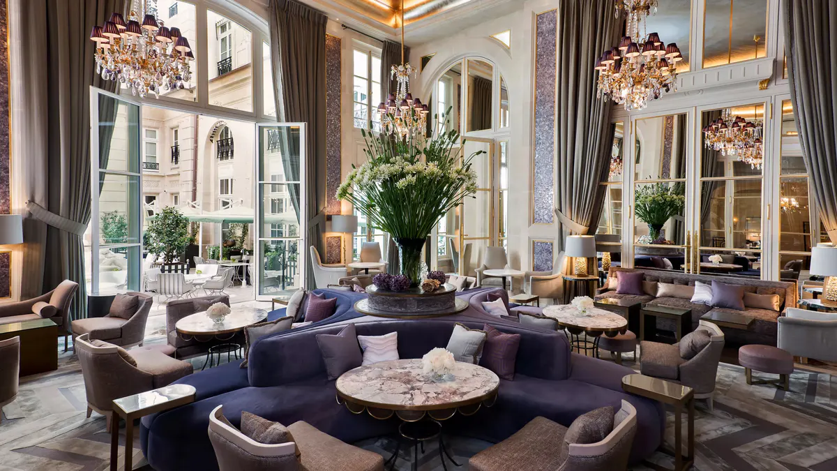 Grand dining room with soaring columns, floral arrangements, and crystal lighting
