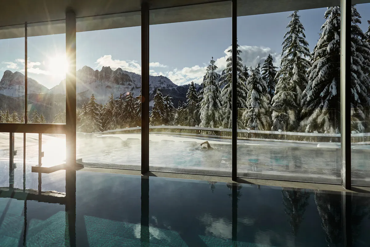A heated pool or water therapy area with light wood surrounds and calm spa-like ambiance