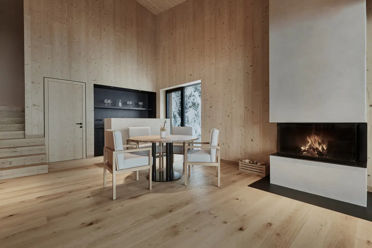 A residential space with neutral furnishings, natural wood accents, and ambient side lighting