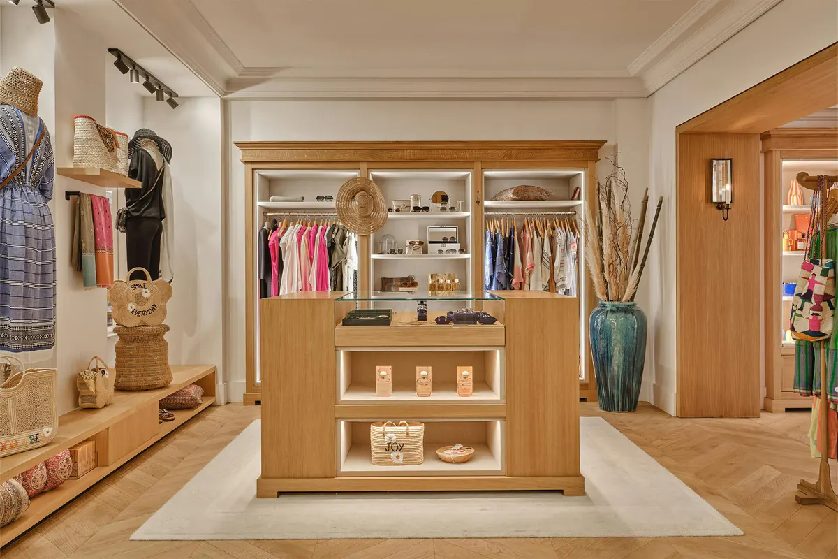 Walk-in dressing room with wooden cabinetry, shelving, and clothing hanging rails