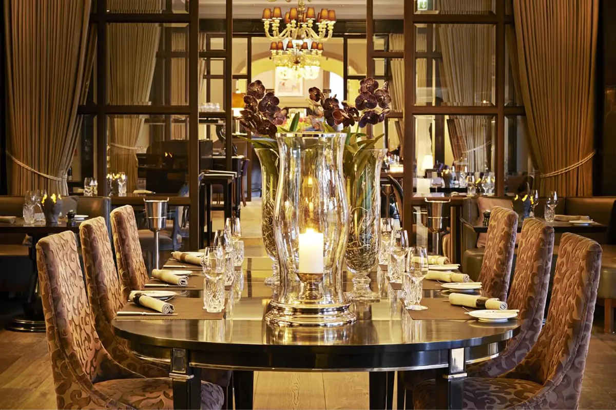 Private dining table set for two with crystal stemware and chandelier