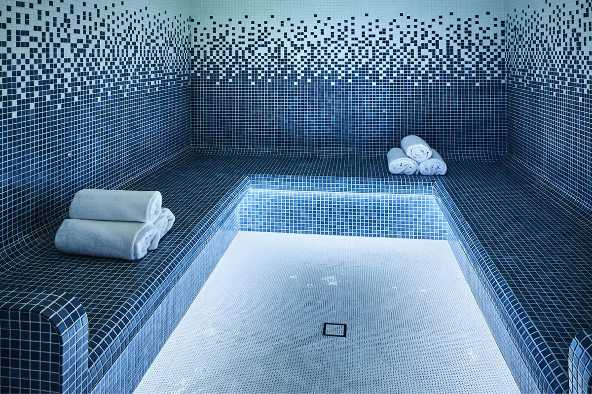 Mosaic tiled hammam pool with rolled towels