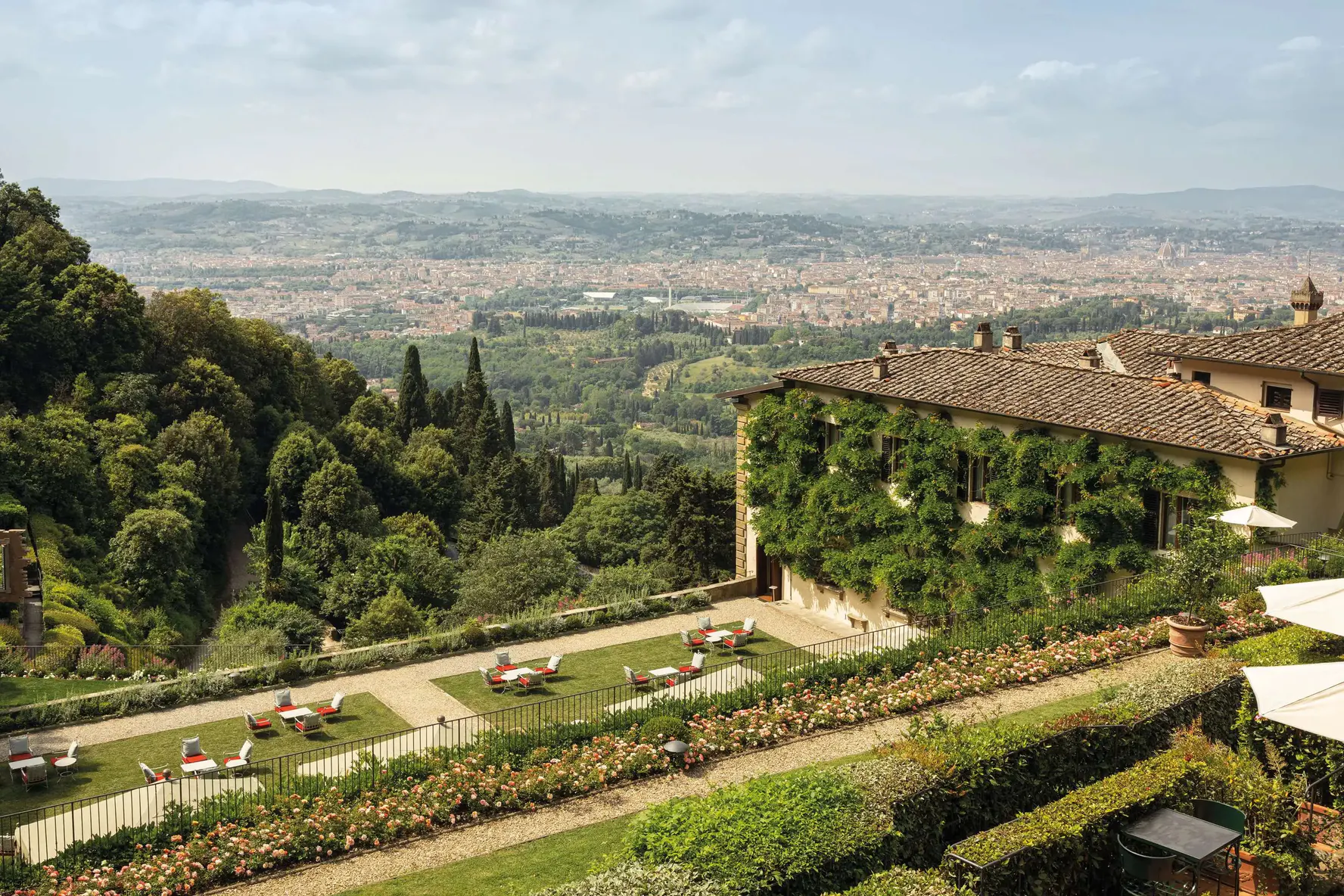 The wisteria-covered wing of Villa San Michele above a rose garden, with Florence spread across the valley below