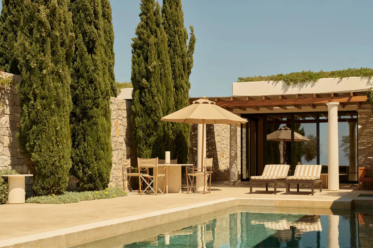 Pool-adjacent loungers overlooking the Peloponnesian coast at dusk