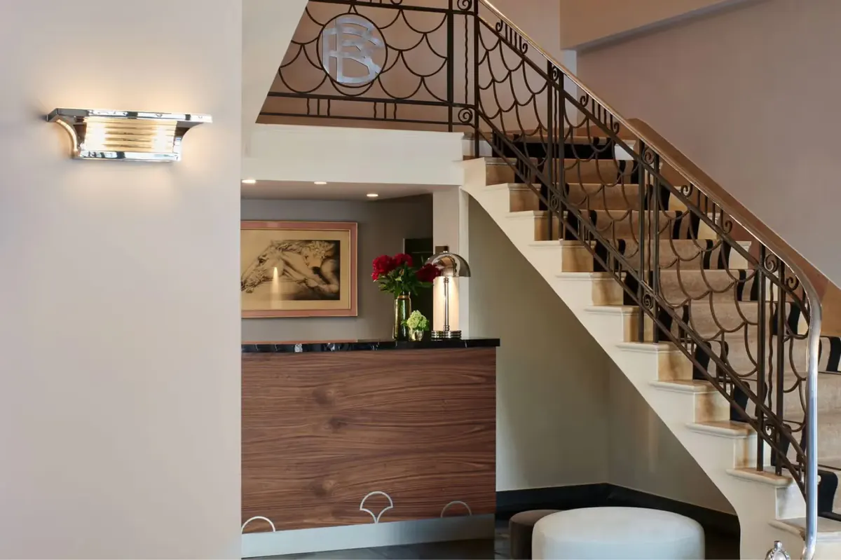 A guest room with modern elements, double-height interior, and metal staircase to upper level