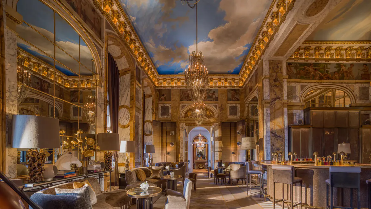 Opulent rococo room with gold ornament, crystal chandelier, and formal table setting